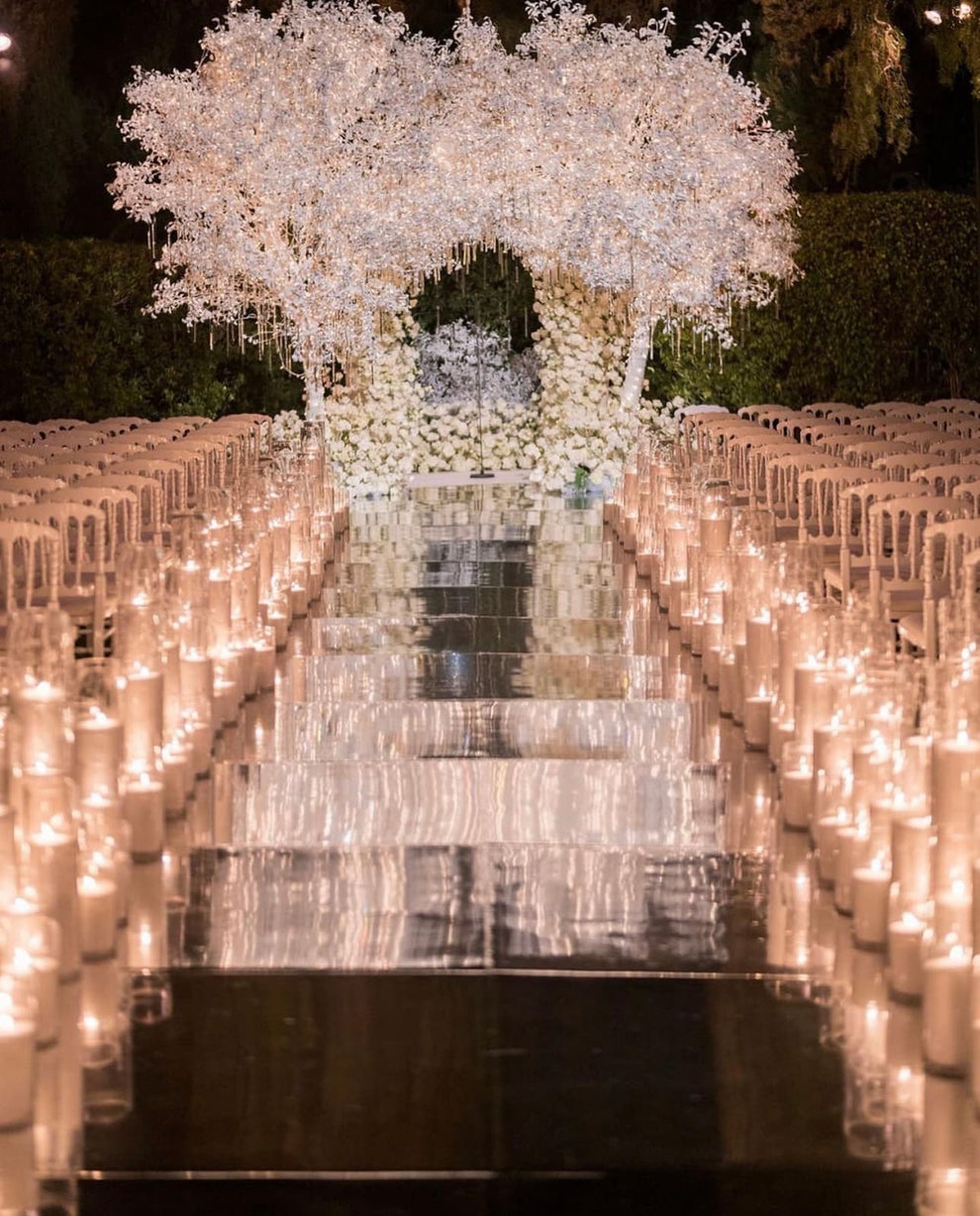 Candlelit wedding aisle leading to a glowing white blossom tree
