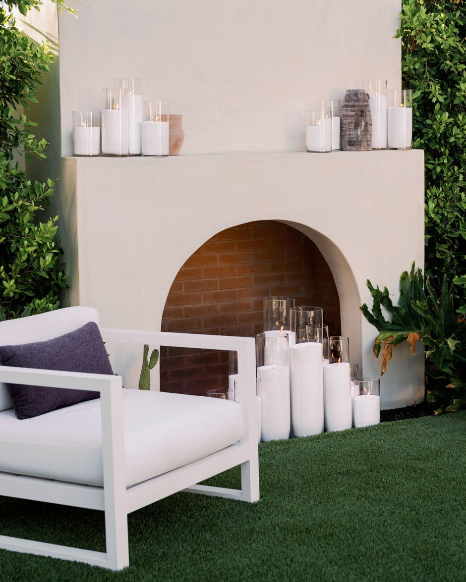 Tall glowing pillar candles framing a refined event setting