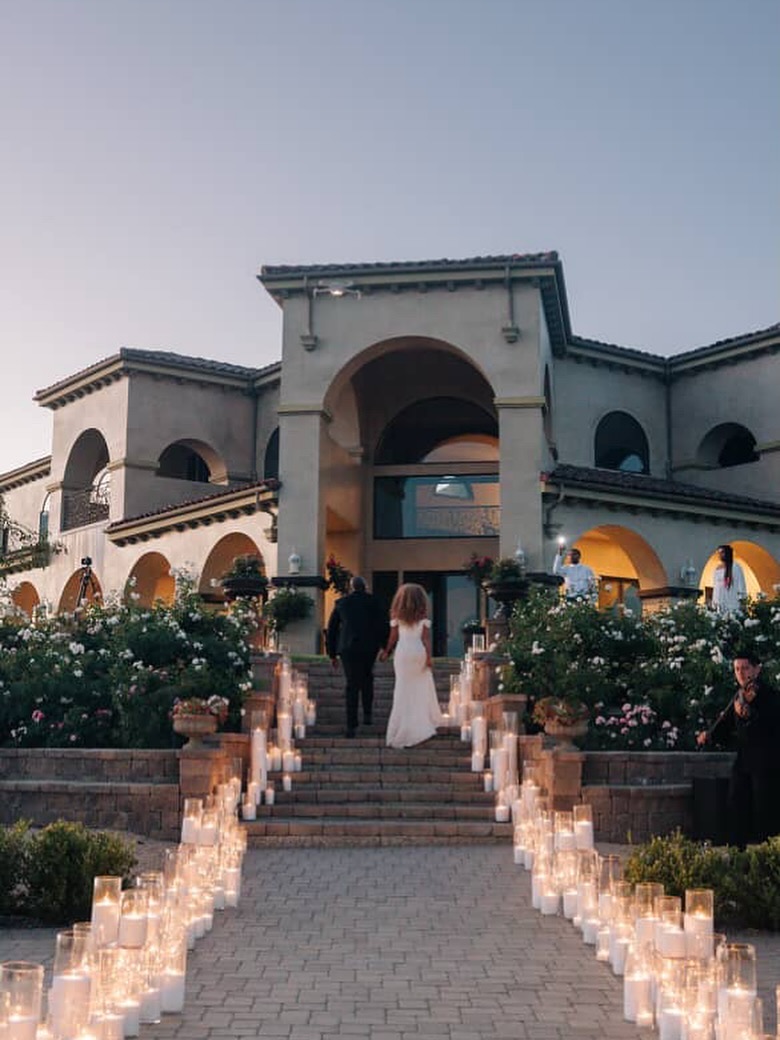 Bride walking a candlelit staircase to a villa at a luxury wedding