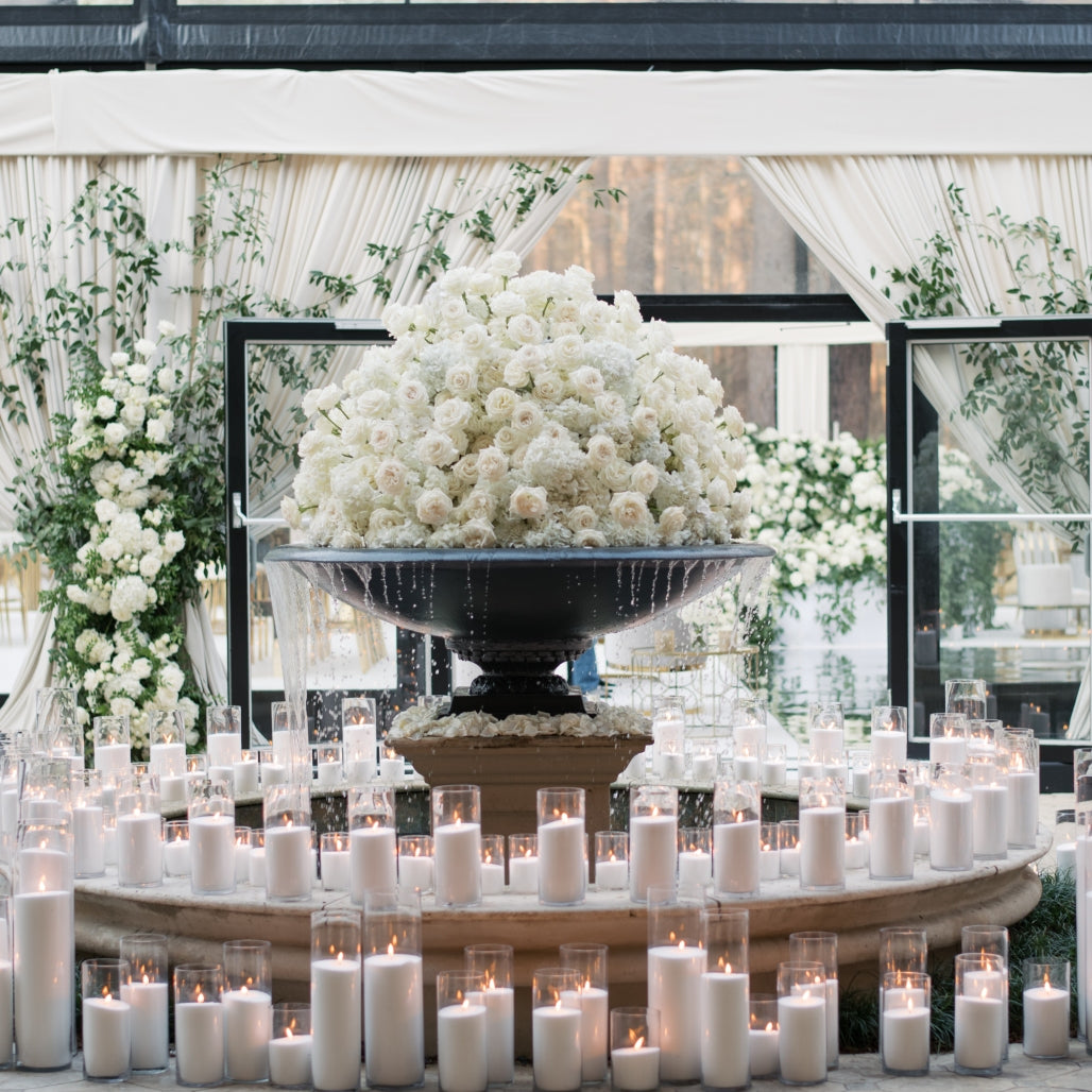 Gala fountain centerpiece framed by white florals and glowing candles